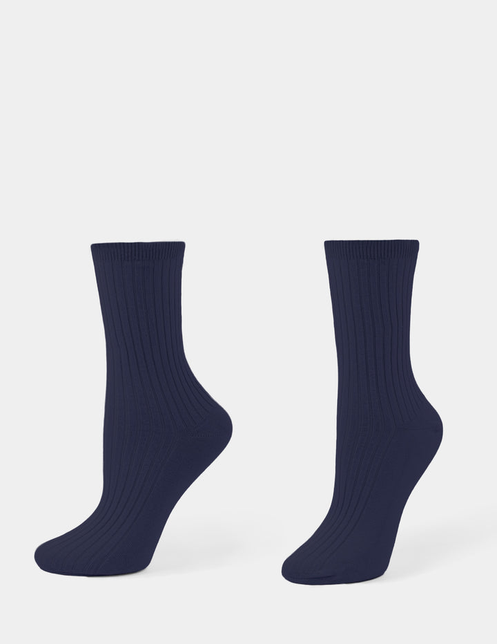 A navy pair of ribbed crew socks displayed against a light gray background.