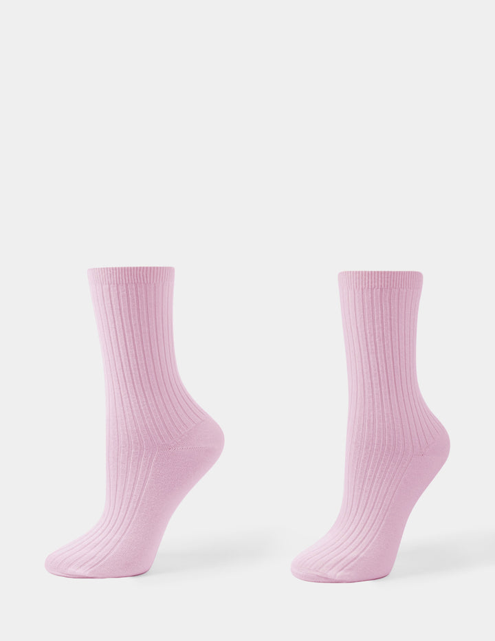 A pair of pink crew socks displayed against a light gray background.
