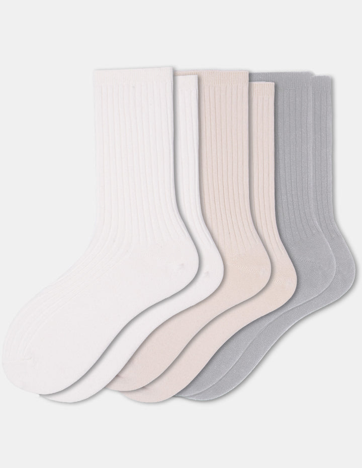 Three pairs of crew socks in ivory, beige, and light grey displayed against a light gray background.