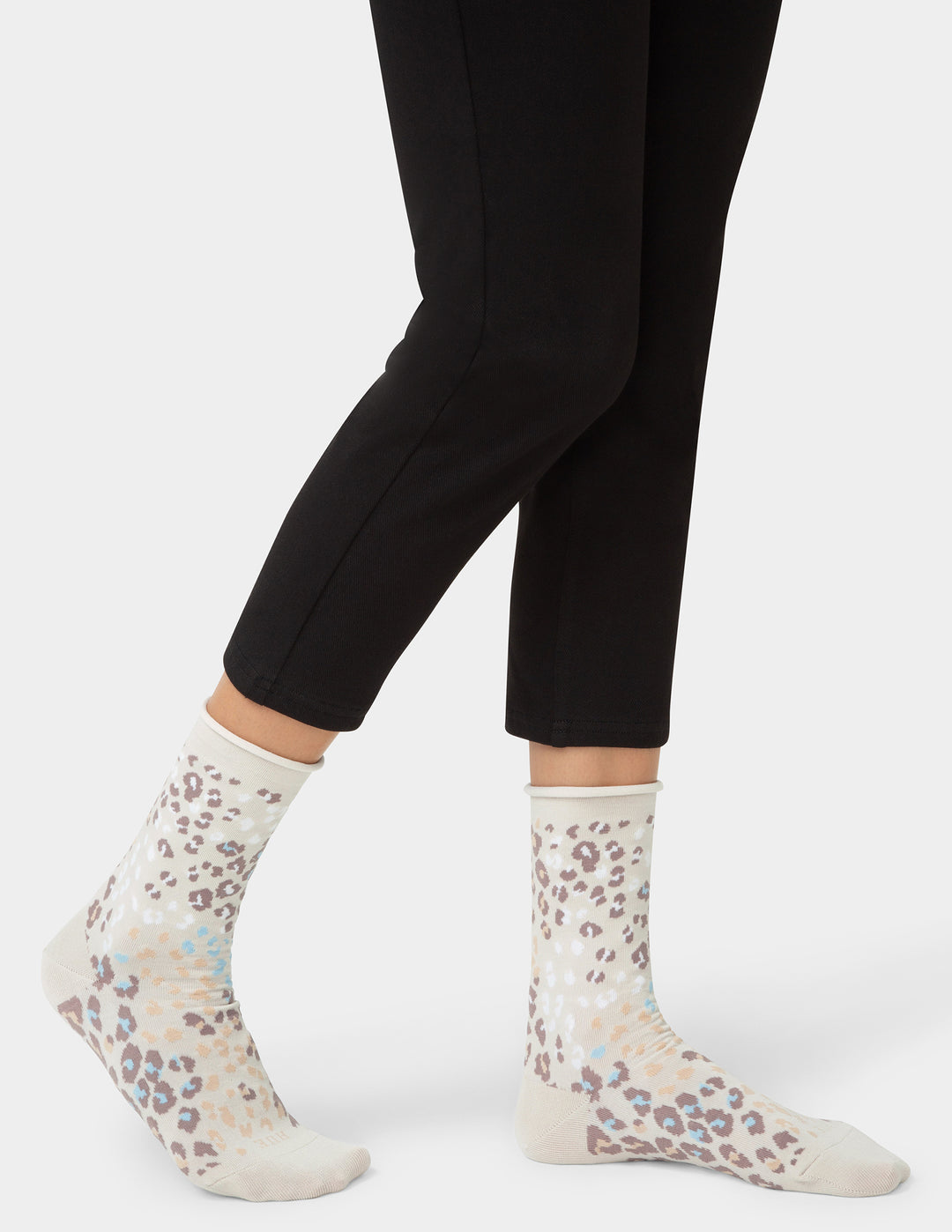 White socks with floral pattern worn with black leggings on a white background