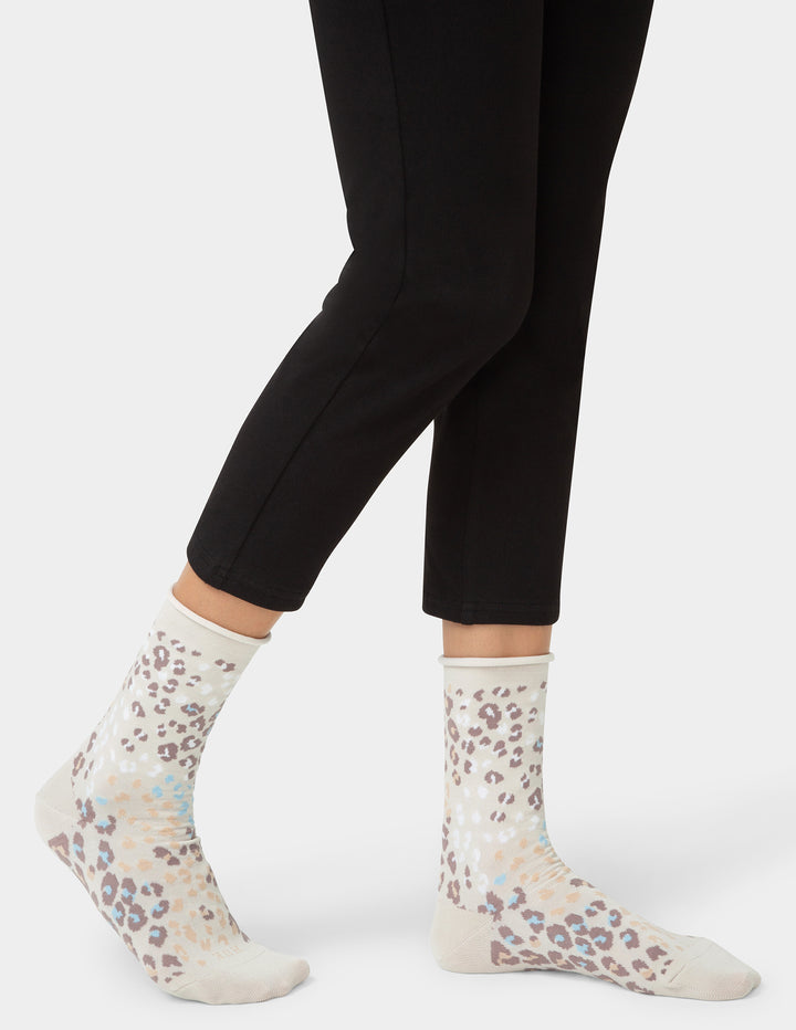 White socks with floral pattern worn with black leggings on a white background