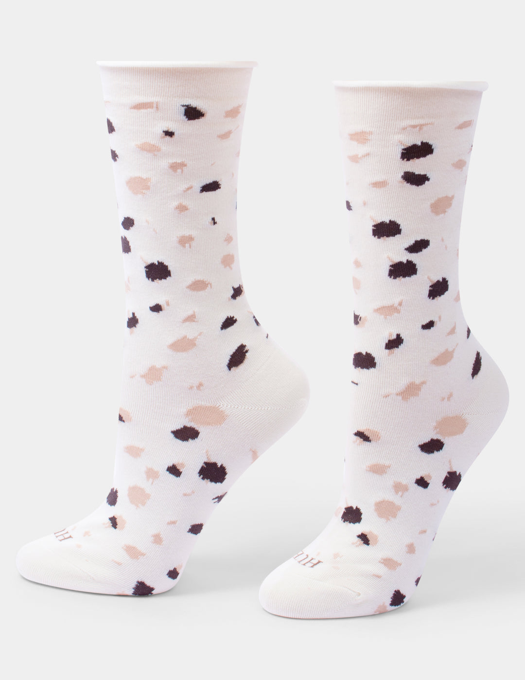 A pair of ivory crew socks with a scattered animal print pattern of black and pink spots, shown against a light gray background.