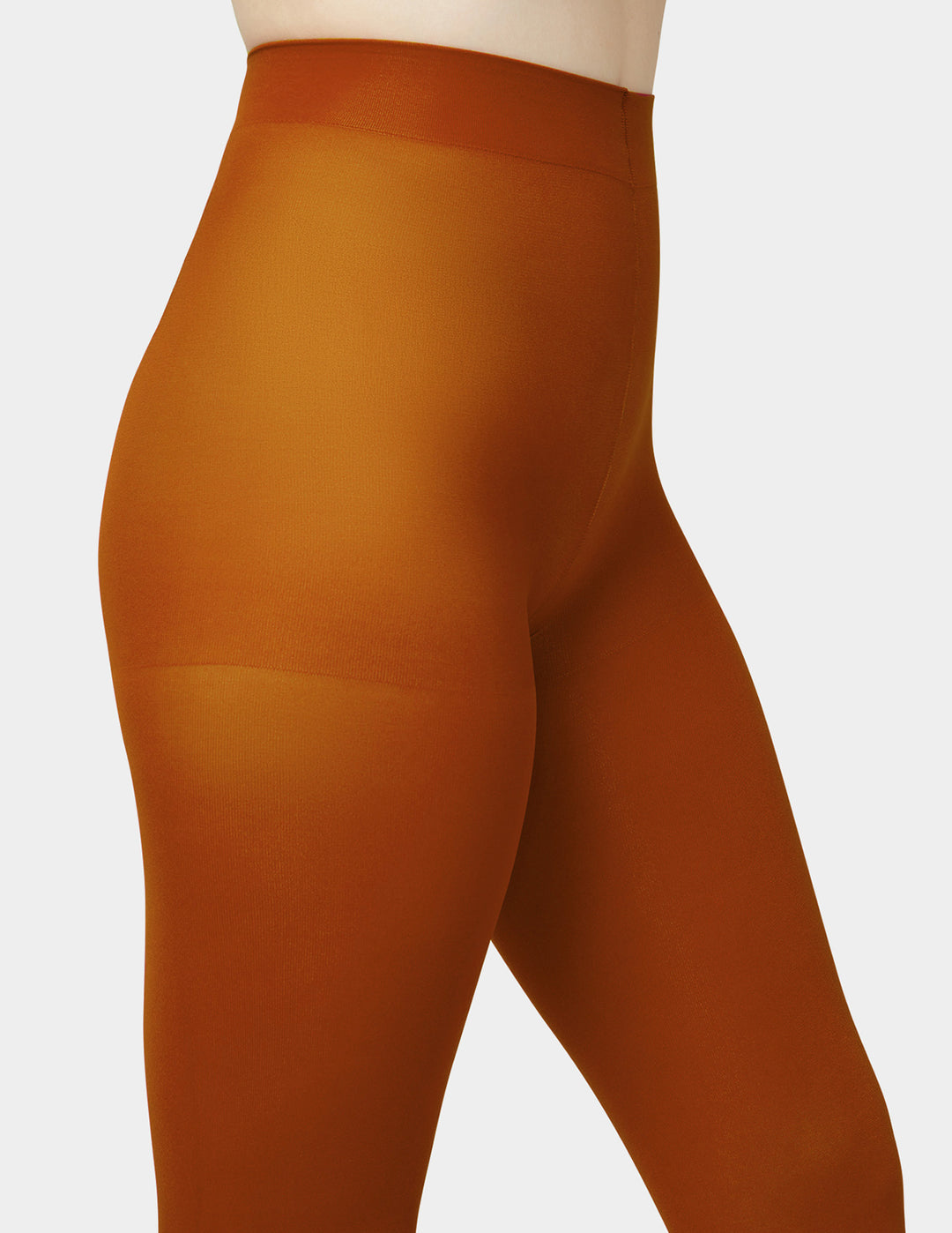 A close-up of a model wearing opaque rust-orange tights against a light gray background.