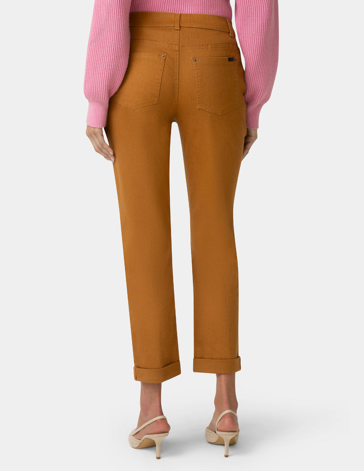 Brown pants worn by a person with a pink top on a white background