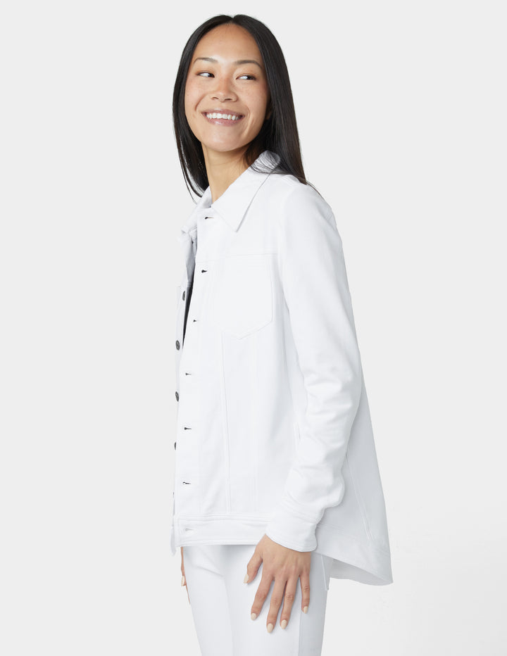 Woman wearing a white shirt with black buttons on a plain background