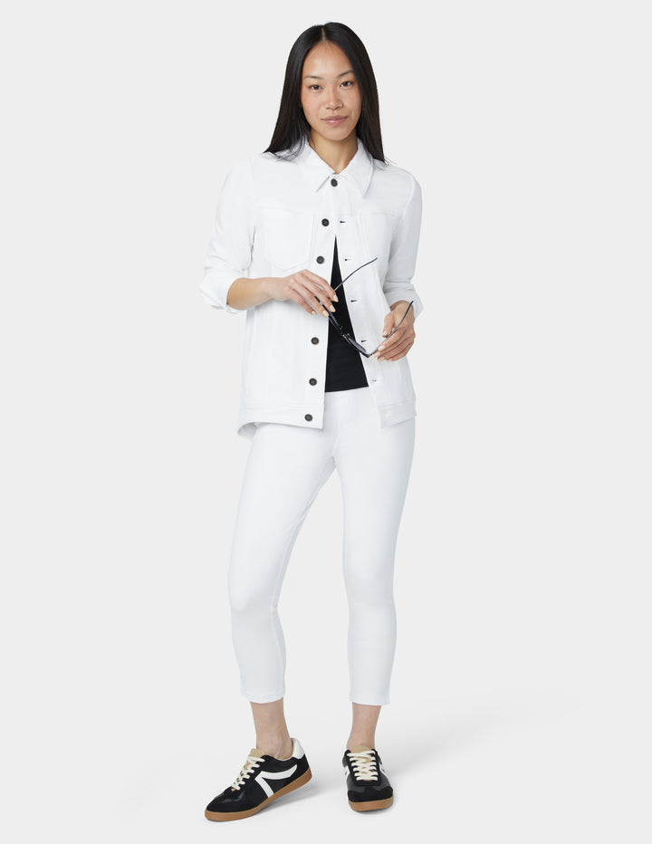 Woman wearing a white outfit with black accents on a white background