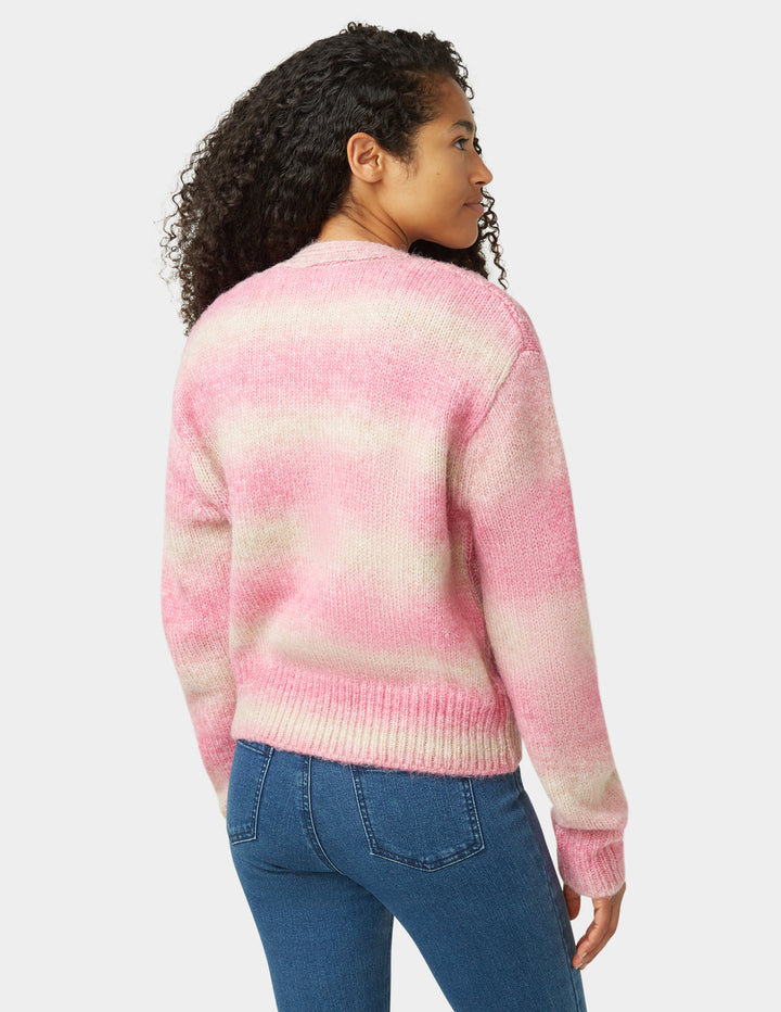Person wearing a pink and white striped sweater on a plain background
