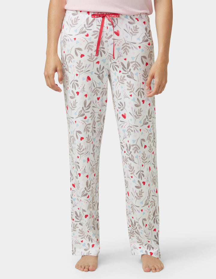 Floral patterned pajama pants worn by a person on a white background