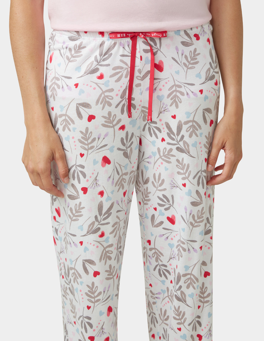 Floral patterned pants with red accents on a white background