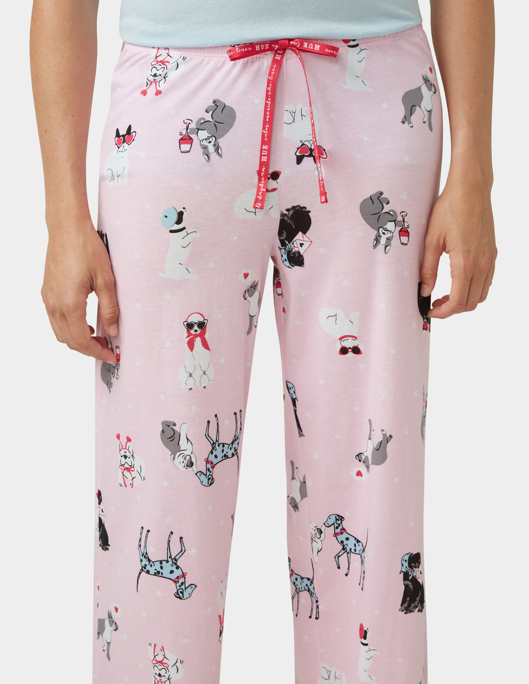 Pink pajama pants with dog pattern on a plain background