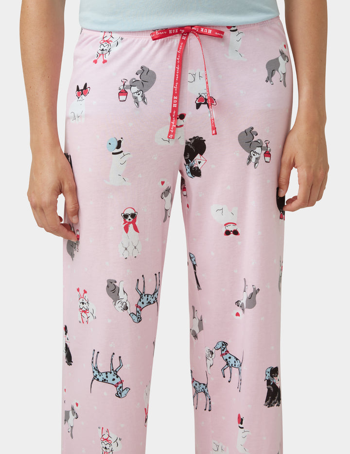 Pink pajama pants with dog pattern on a plain background