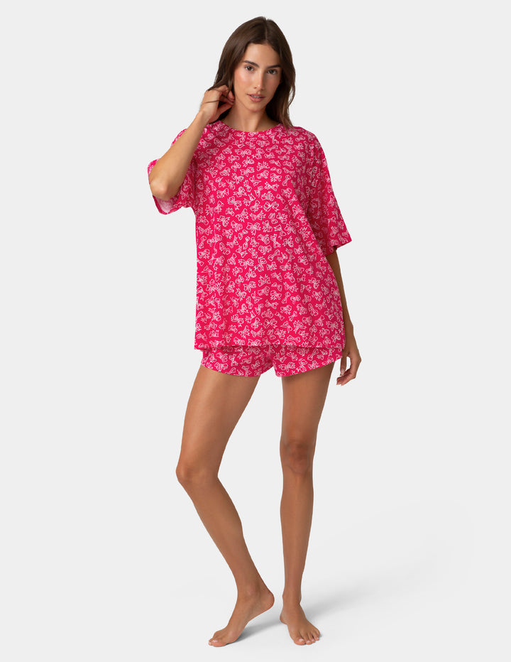 Woman wearing a pink bow nightshirt on a white background