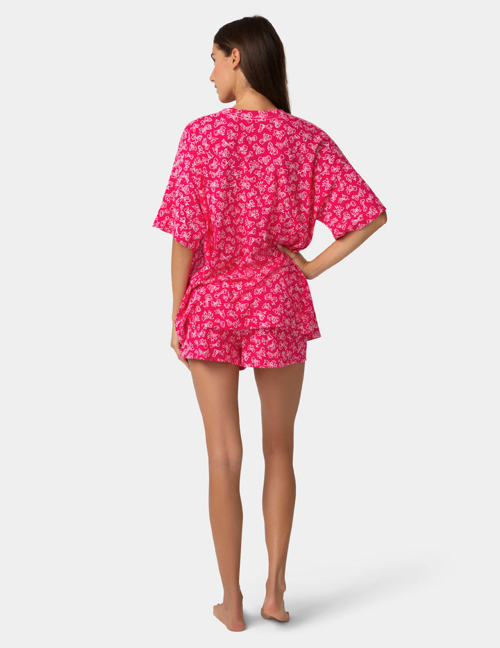 Woman wearing a pink bow pj set on a white background