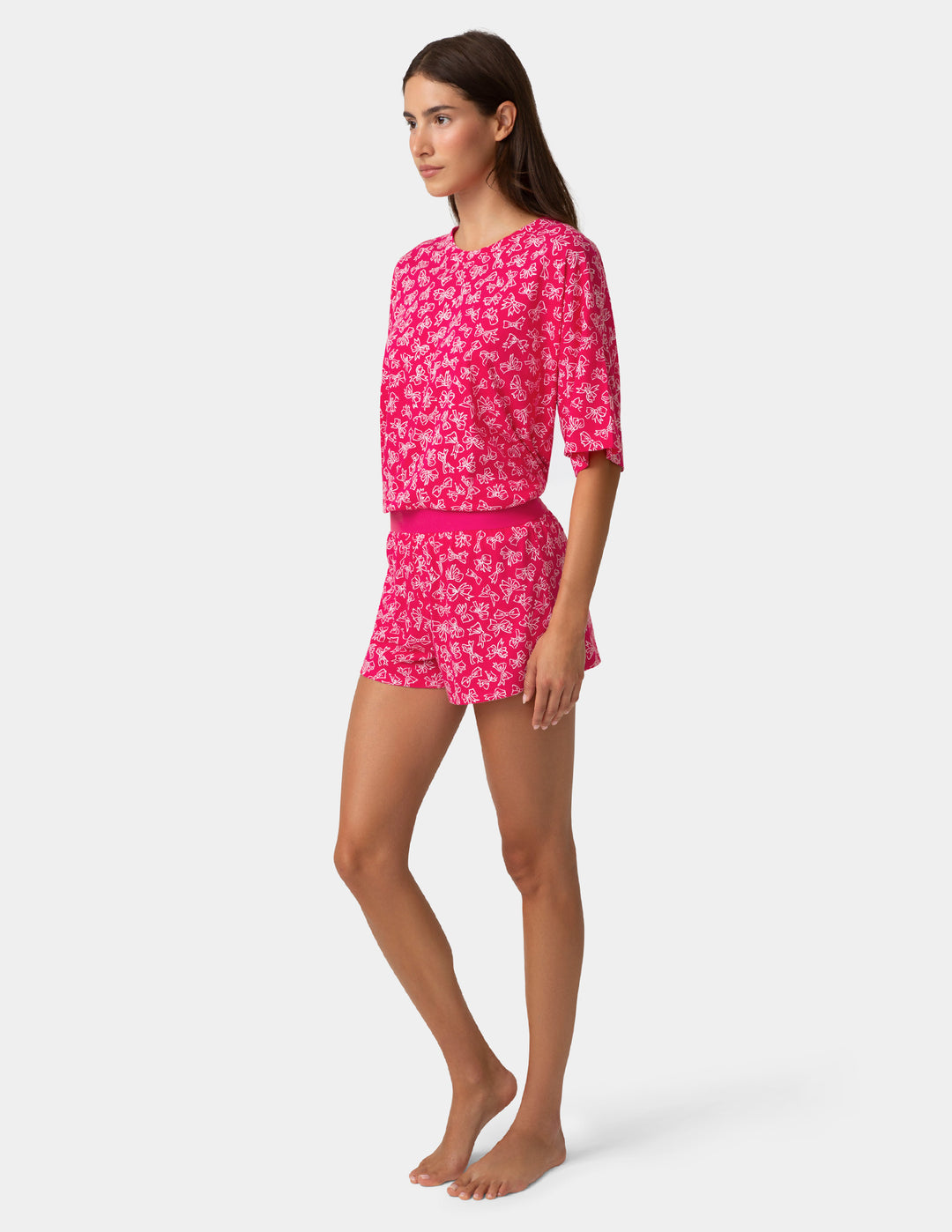 Woman wearing a pink bow outfit on a white background