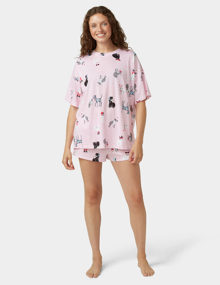 Woman wearing light pink pajama set on white background