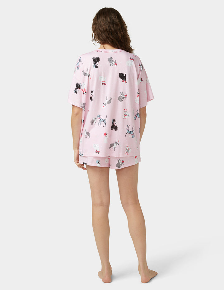 Woman wearing light pink pajama set on white background