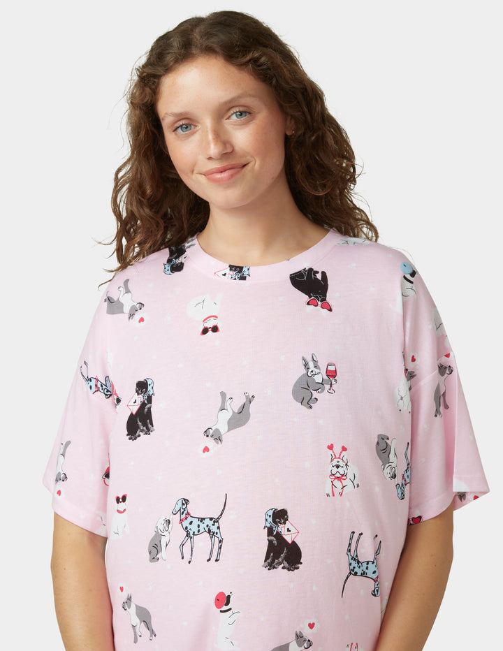 Woman wearing light pink pajama shirt on a white background