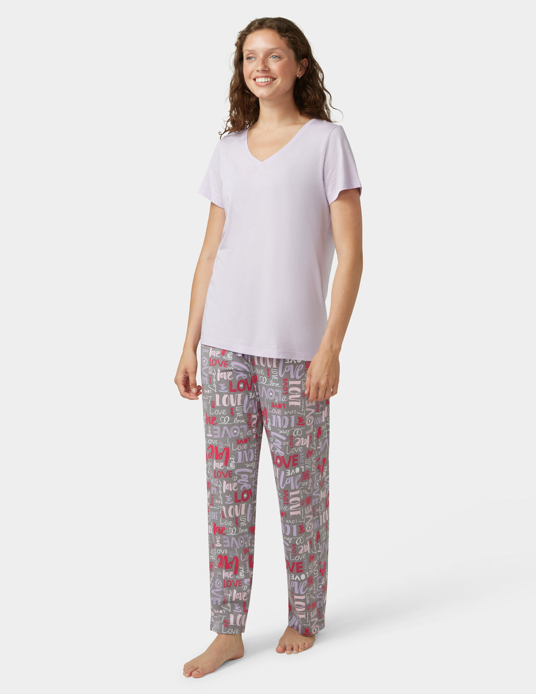 Woman wearing a white top and patterned pants on a white background