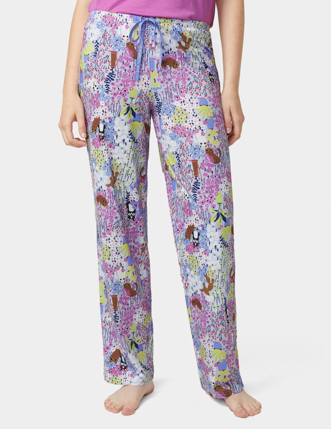 Multicolored patterned pajama pants worn by a person on a white background
