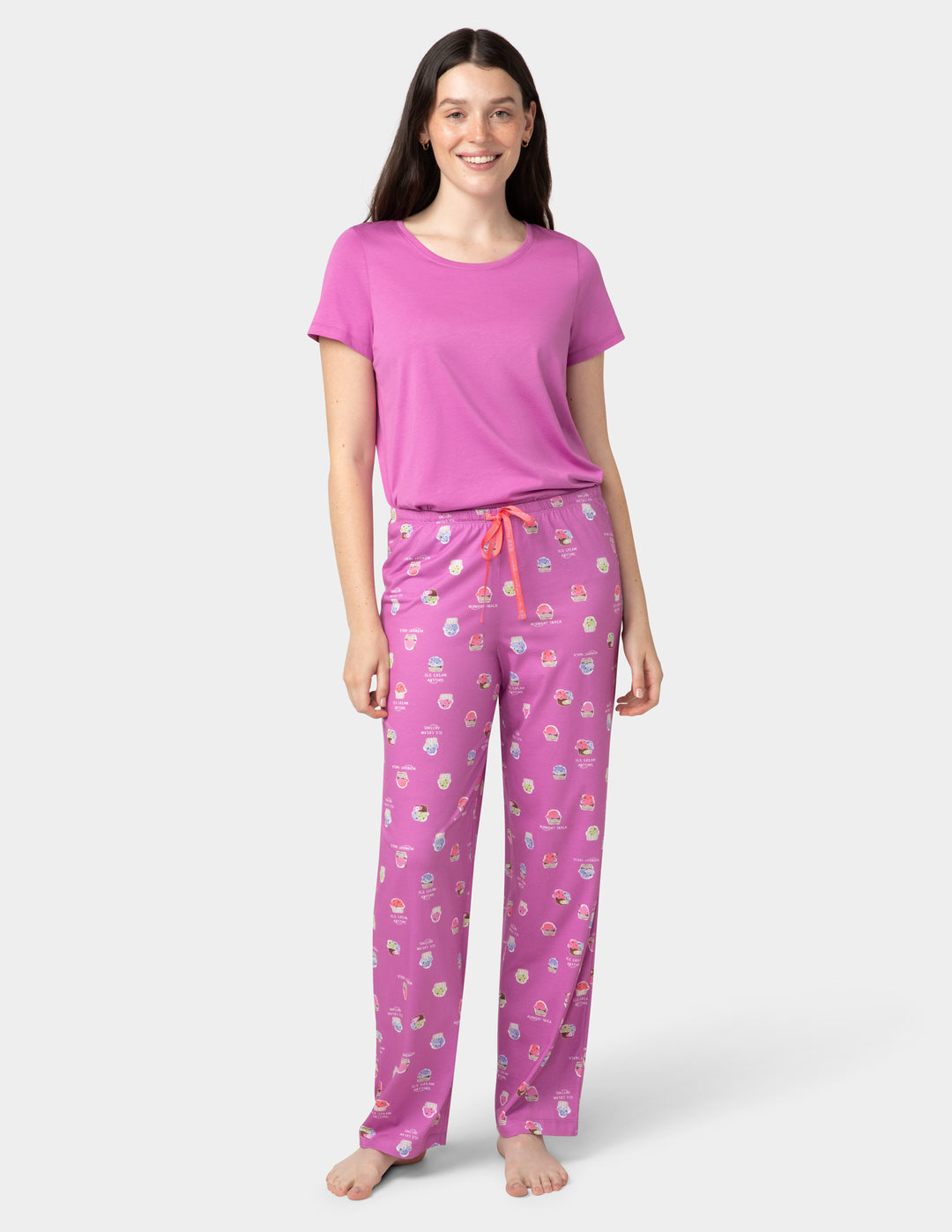 Woman wearing a pink pajama set with a white background