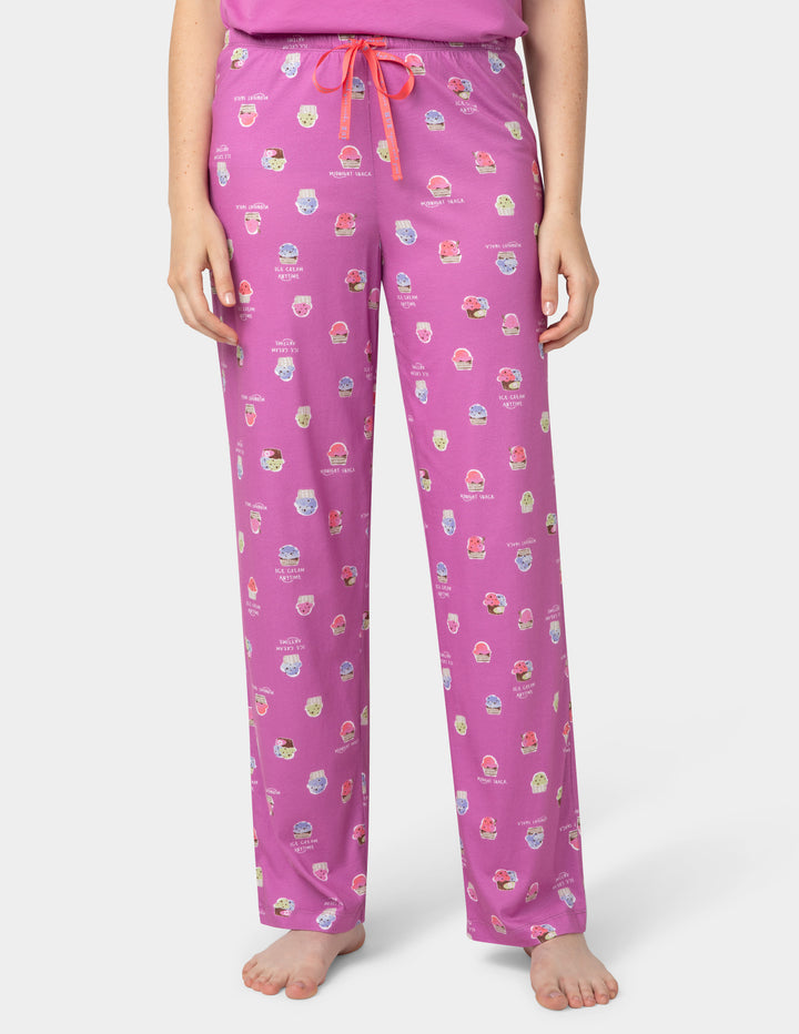 Pink pajama pants with colorful patterns on a white background
