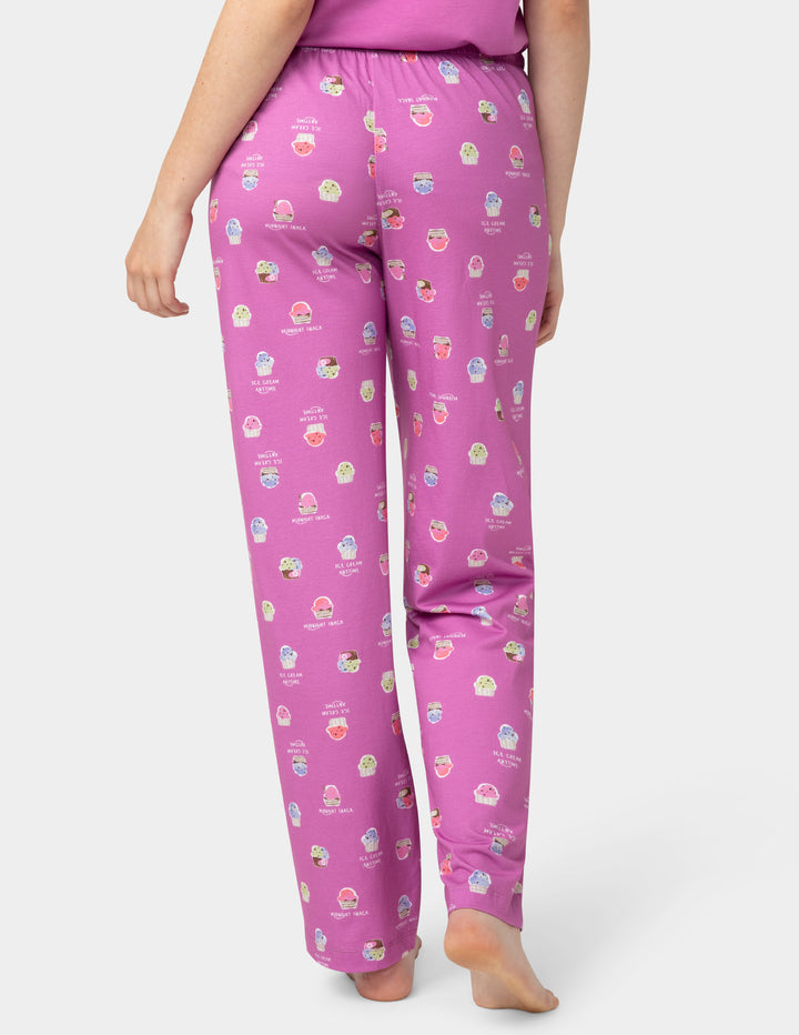 Person wearing pink pajama pants with a pattern on a white background