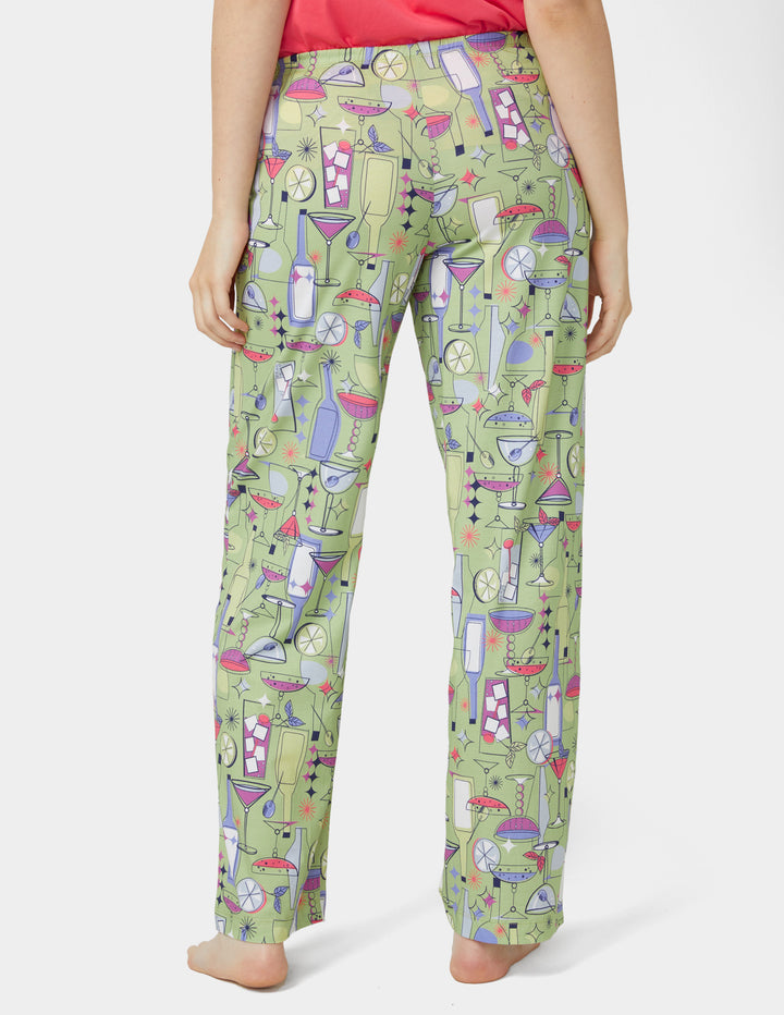 Green pajama pants with cocktail pattern worn by a person on a white background