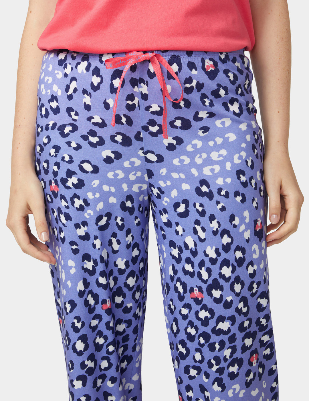 Purple leopard print pants with a pink drawstring worn by a person