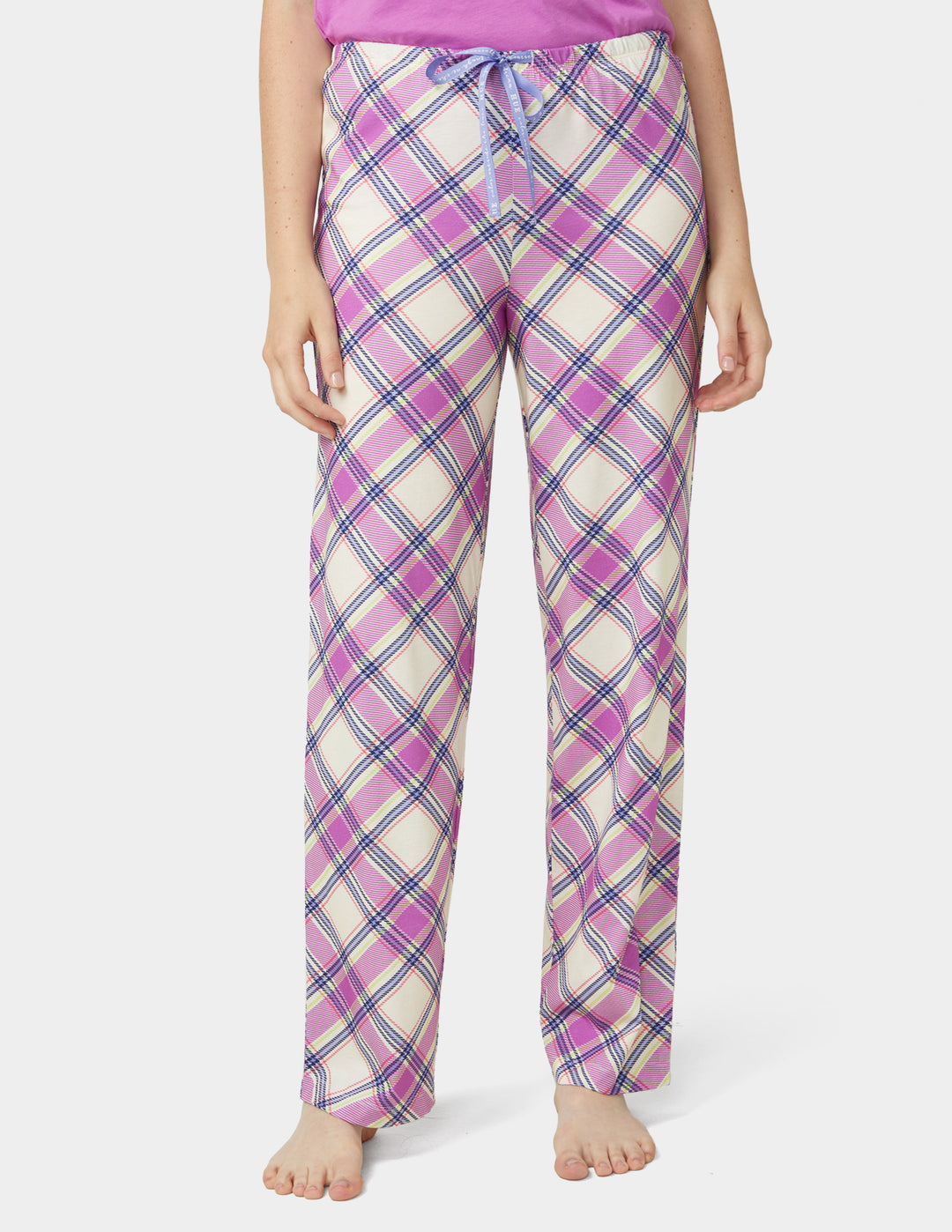 Person wearing pink and purple plaid pajama pants on a white background