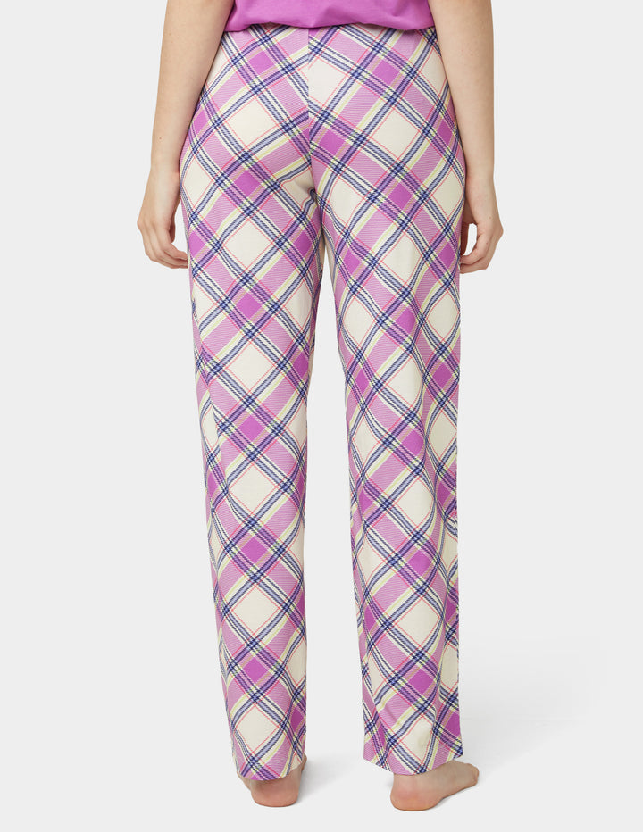 Person wearing pink plaid pajama pants on a white background
