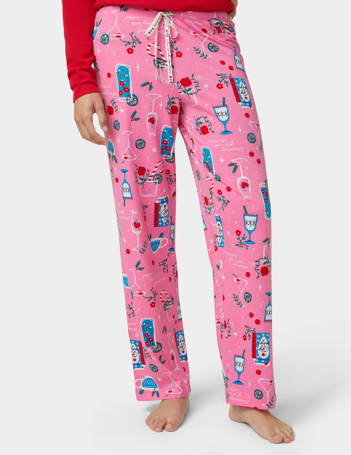 Pink pajama pants with a pattern worn by a person on a white background