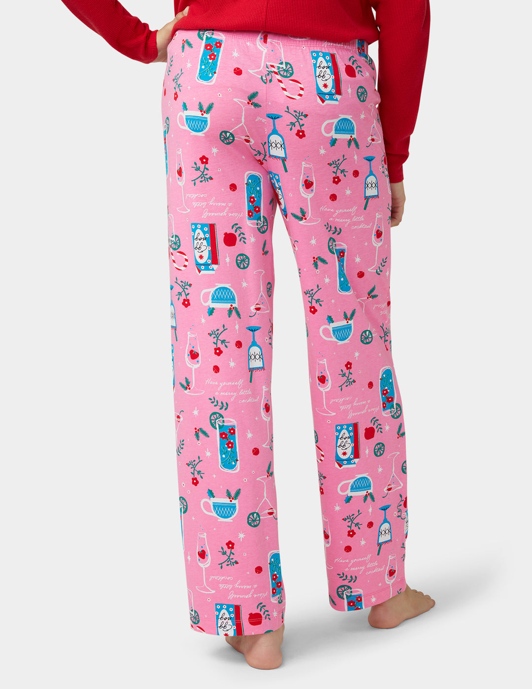 Pink pajama pants with cocktail pattern worn by a person on a white background