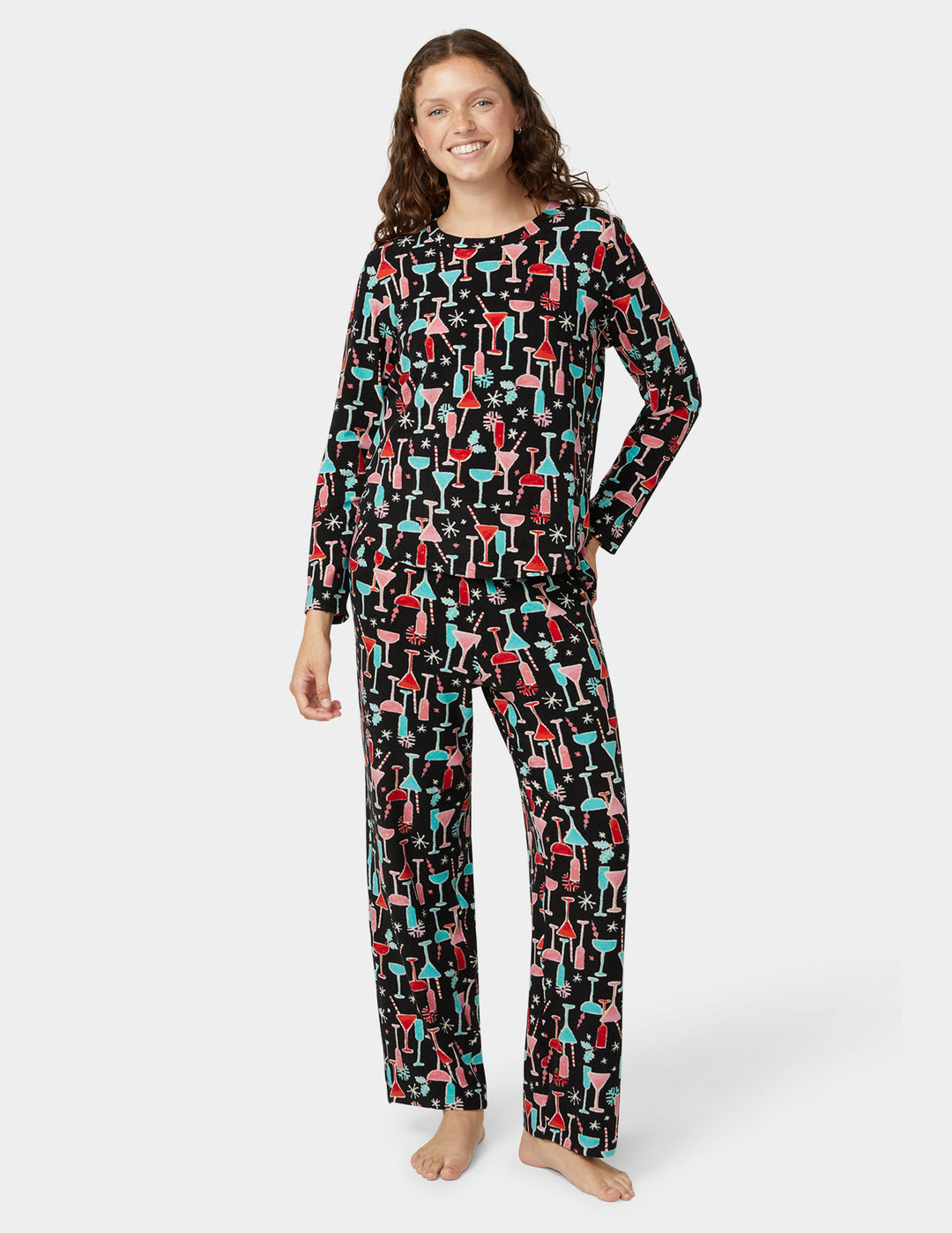 Woman wearing a black pajama set with colorful abstract patterns on a white background