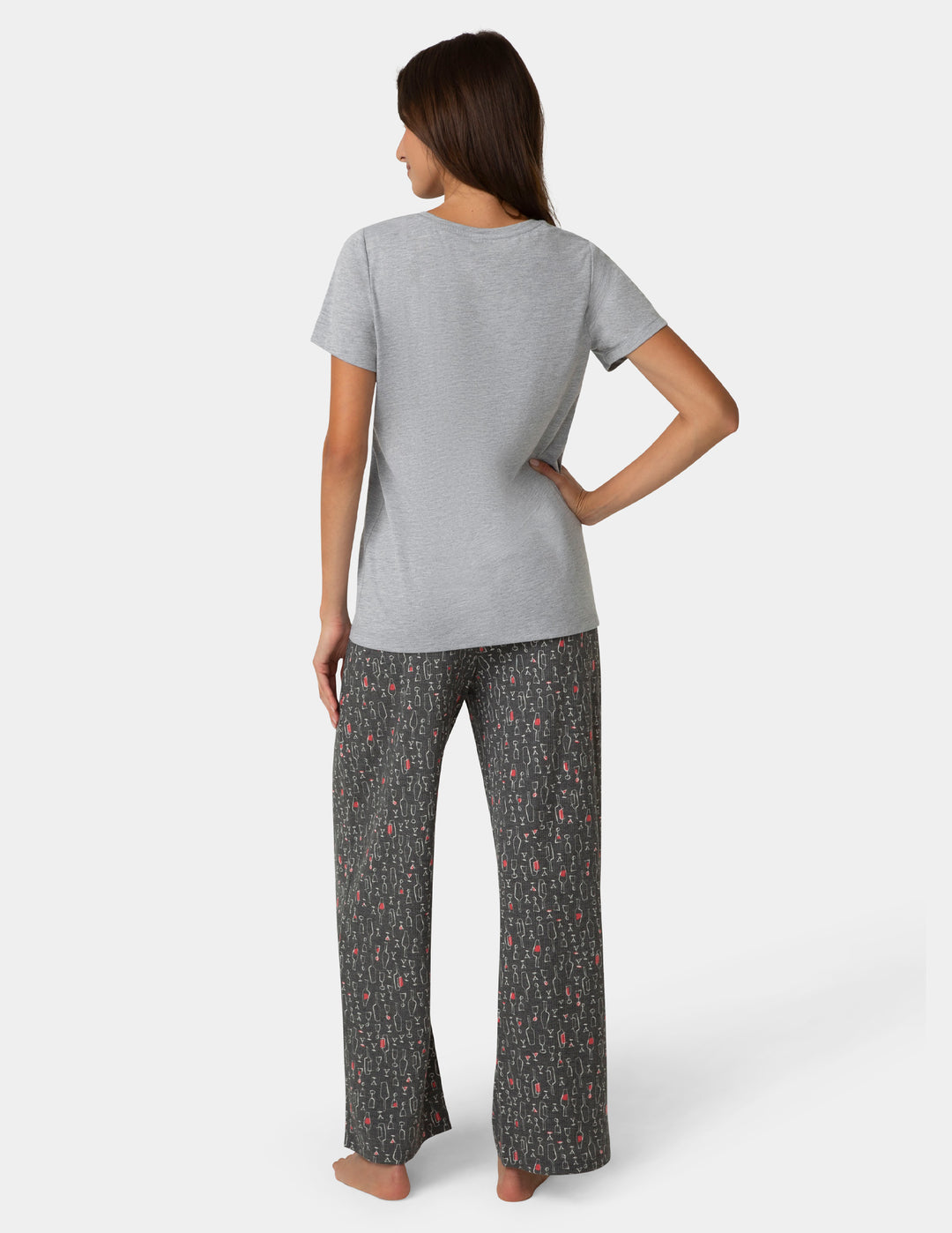 Woman wearing a gray t-shirt and patterned pants on a white background