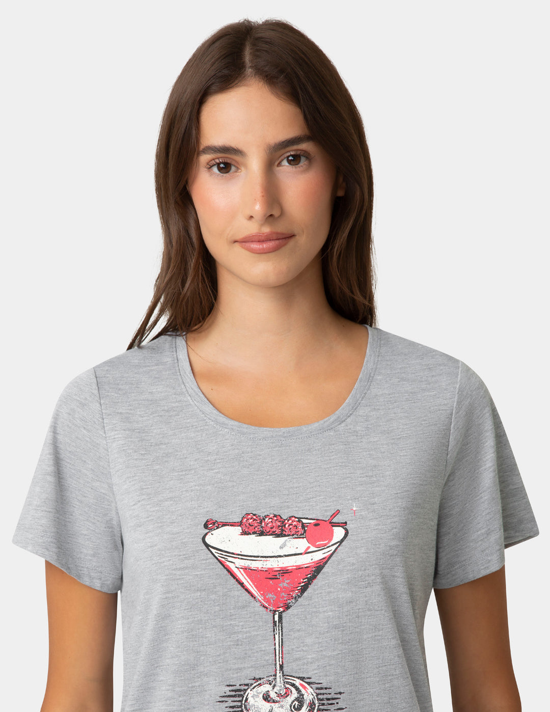 Woman wearing a gray t-shirt with a cocktail graphic on a white background