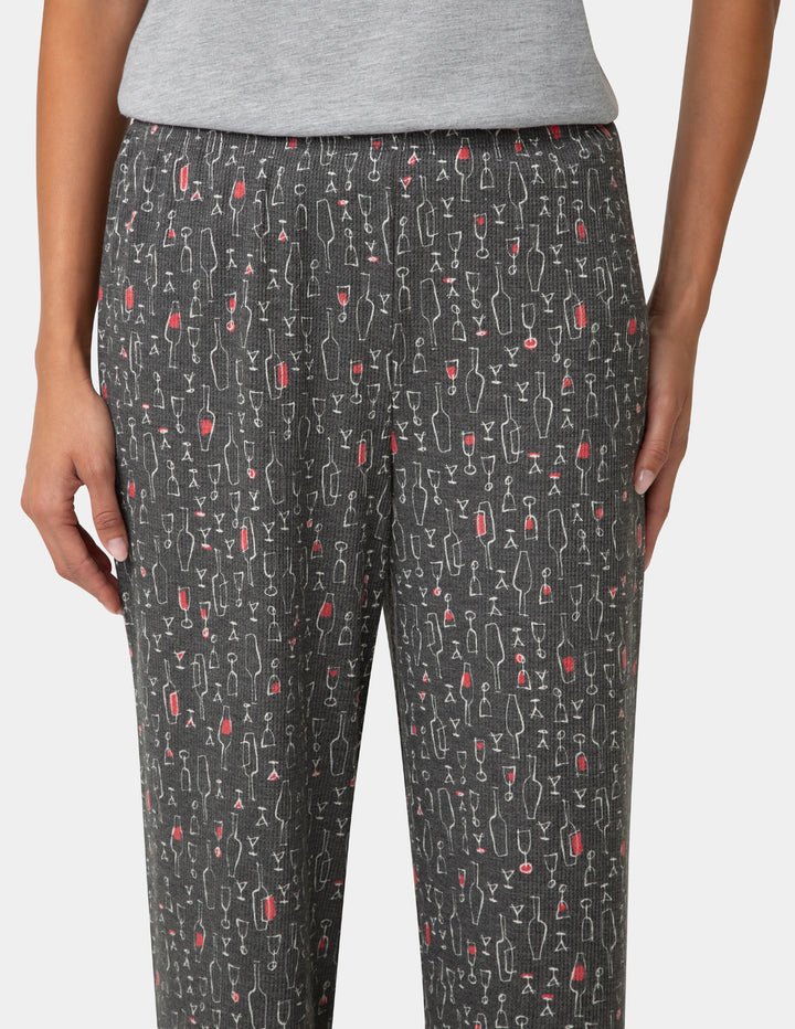 Pants with a pattern of wine glasses and bottles on a plain background