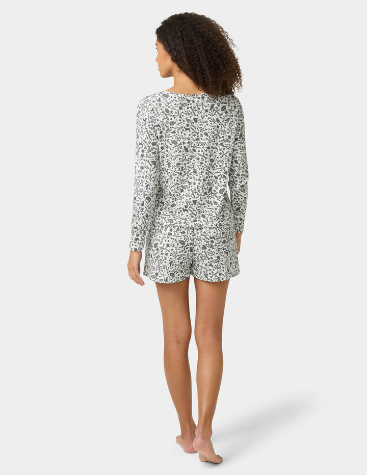 Woman wearing a patterned pajama set on a white background