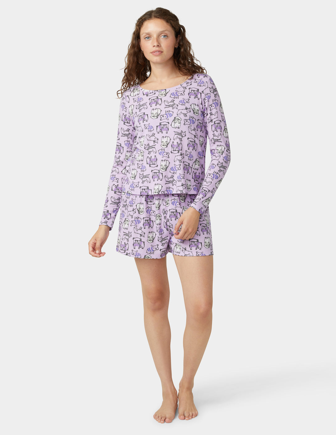 Woman wearing a purple dog pajama set on a white background