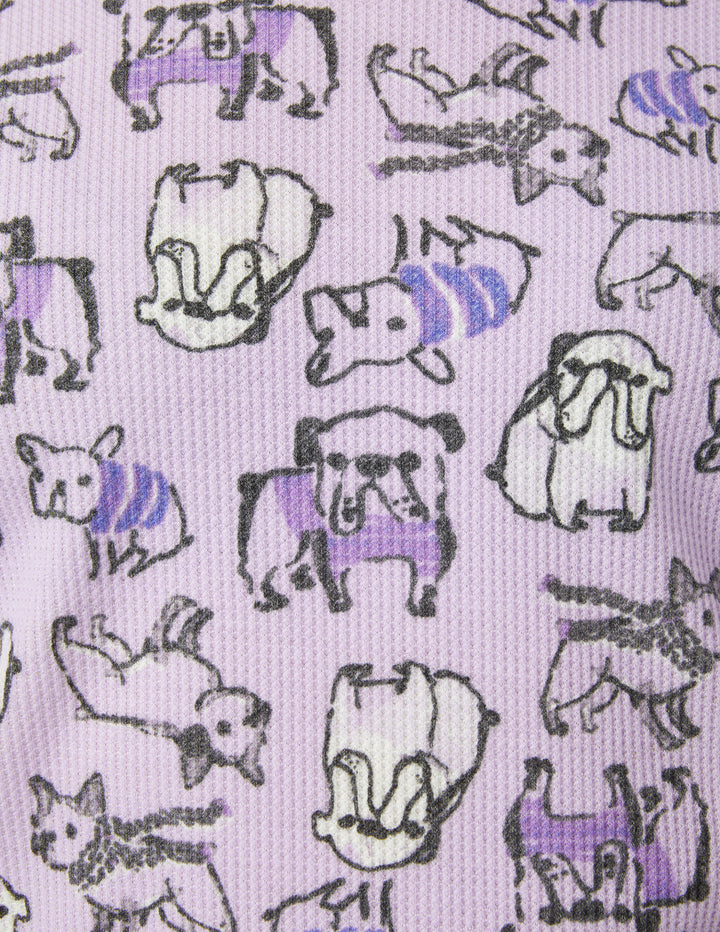 Pattern of cartoon dogs in sweaters on a light purple background