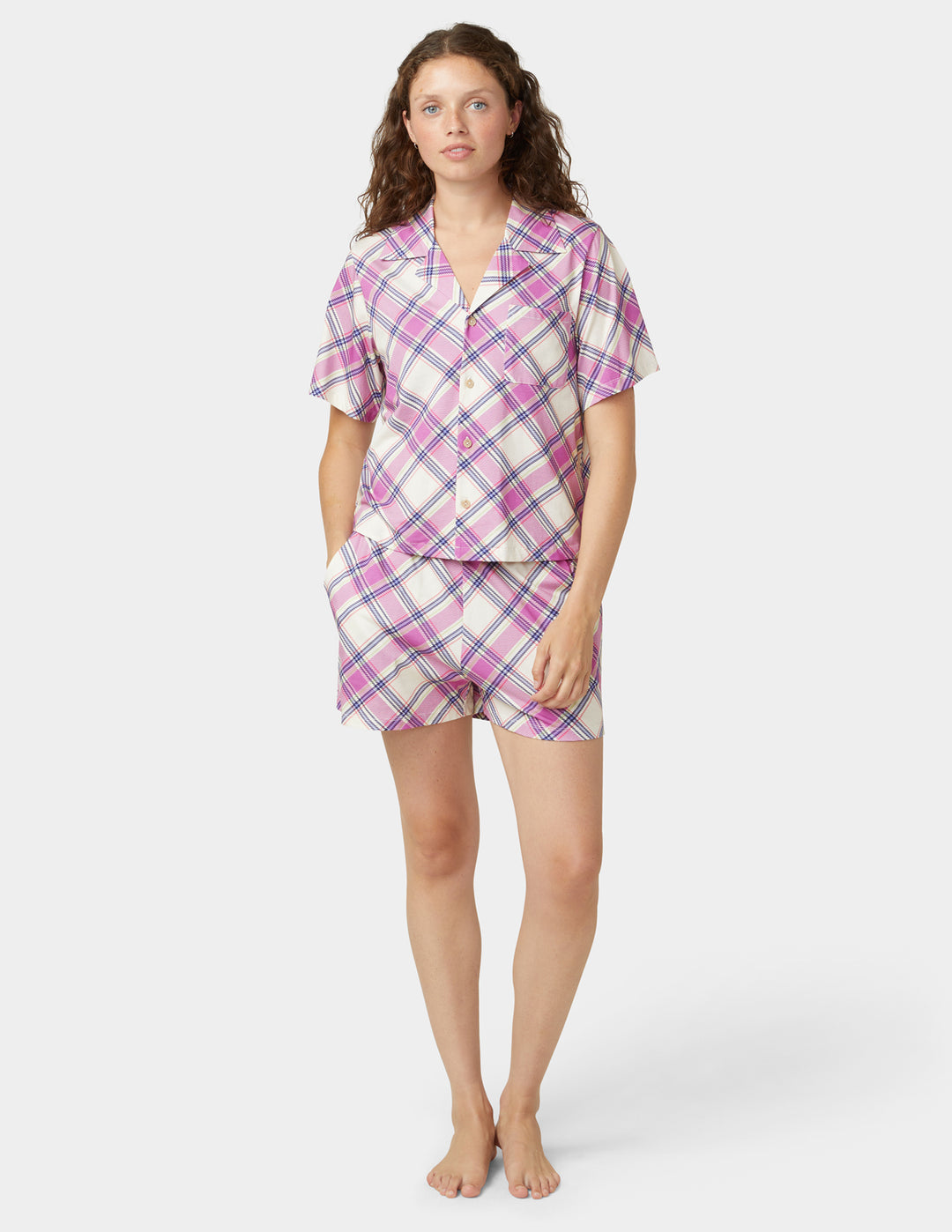 Woman wearing a plaid pajama set on a white background