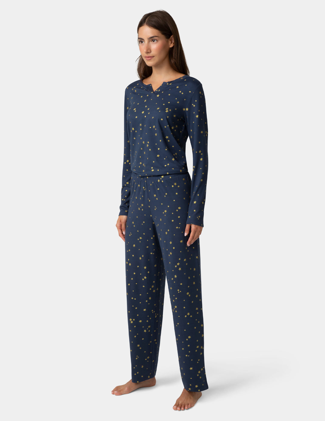 Woman wearing navy blue pajamas with a star pattern on a white background