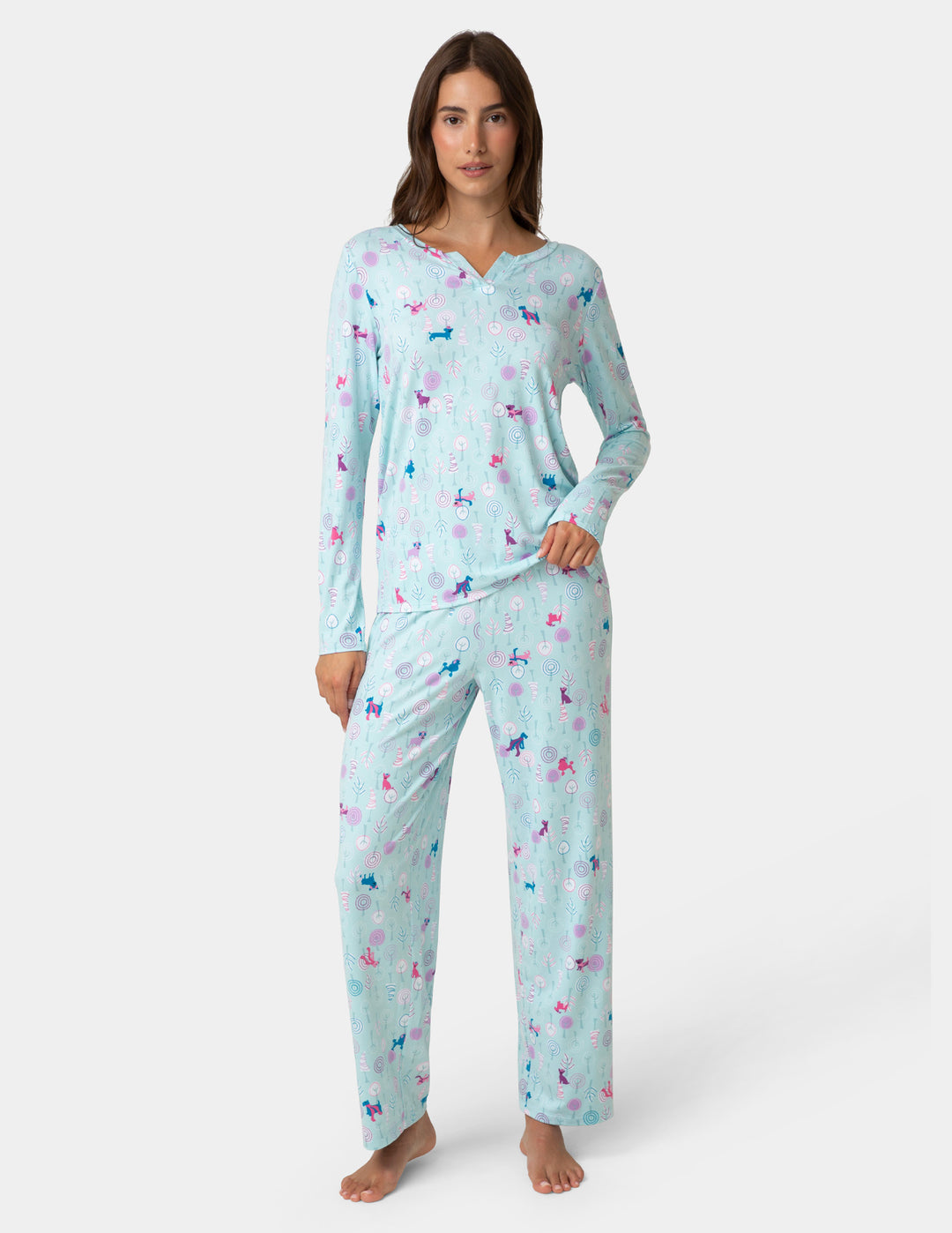 Woman wearing a light blue pajama set with colorful animal prints on a white background
