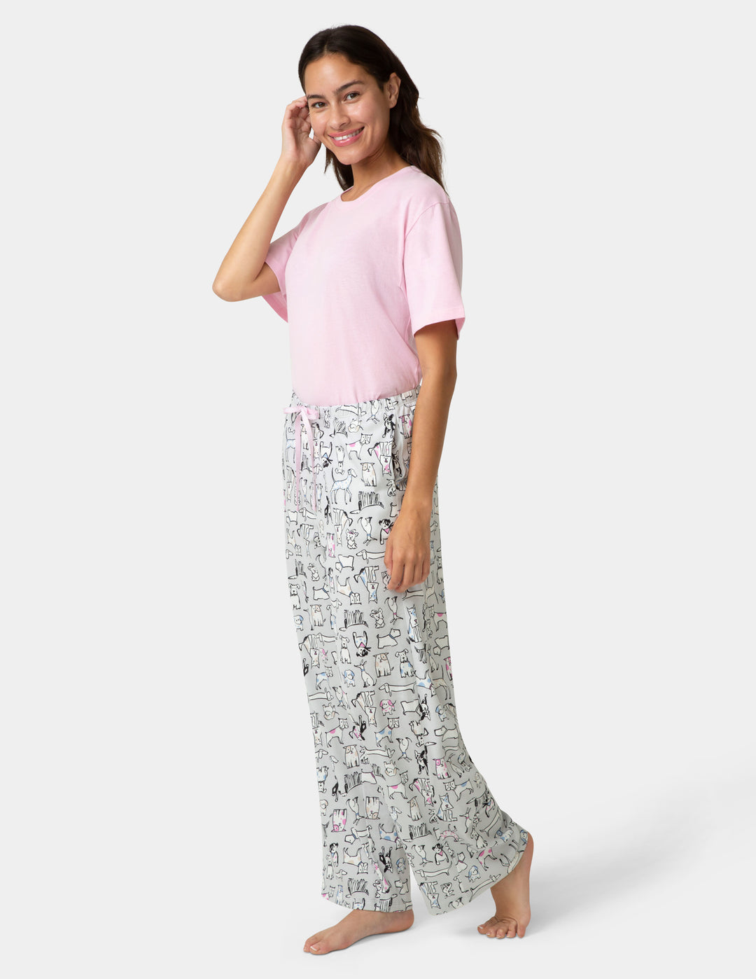 Woman wearing a pink top and patterned pants on a white background