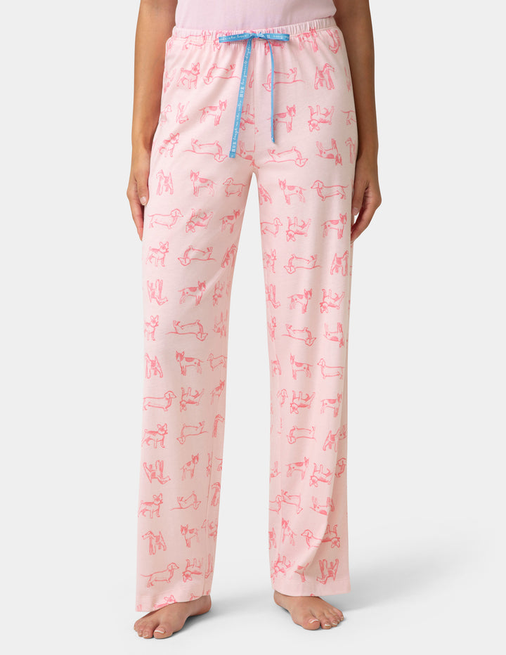 Person wearing pink pajama pants with a pattern on a white background