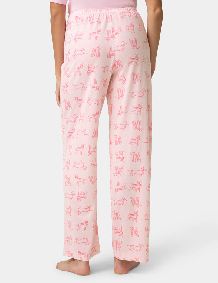 Pink pajama pants with red text pattern on a white background