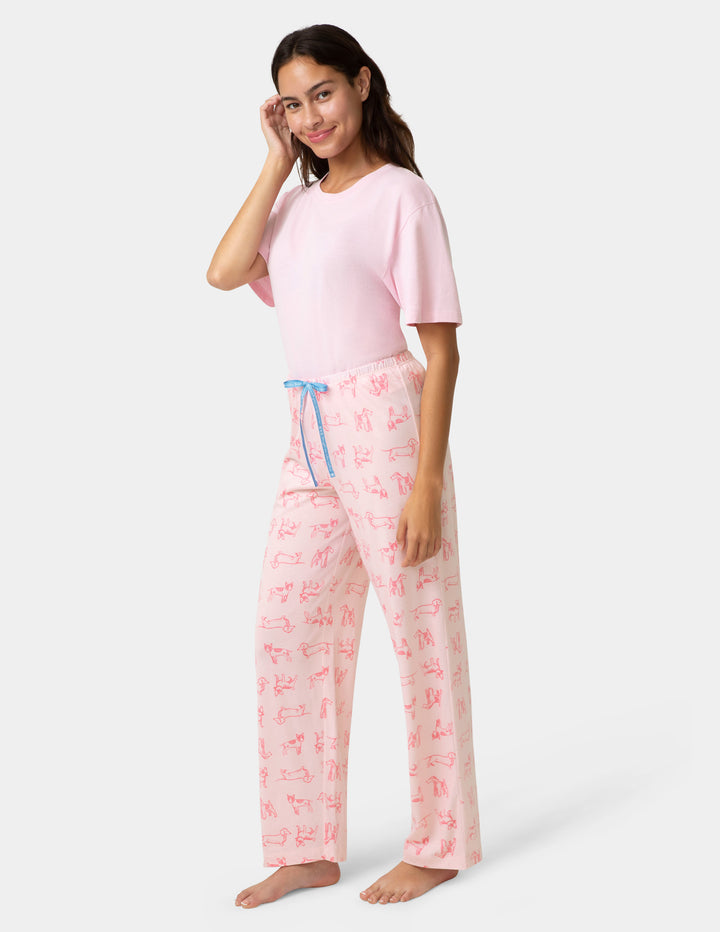 Woman wearing a pink pajama set with a white background