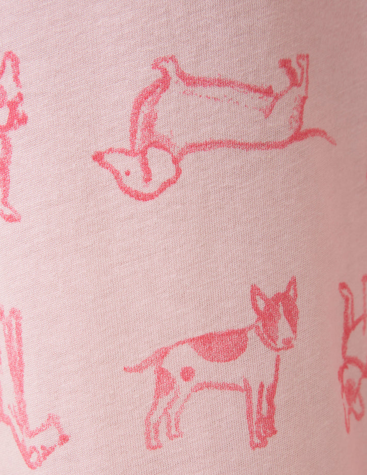 Pink fabric with red dog illustrations on a pink background