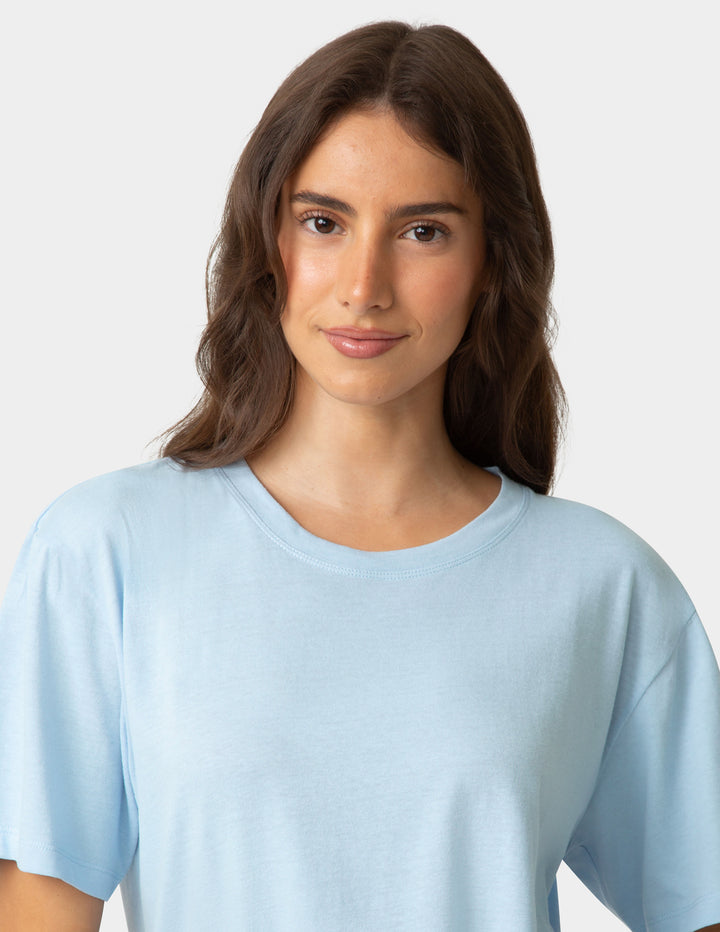 Woman wearing a light blue t-shirt against a plain background