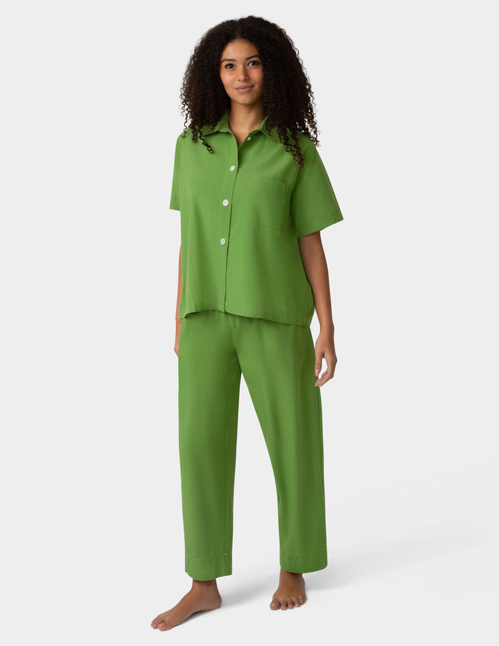 Woman wearing a green pajama set on a white background