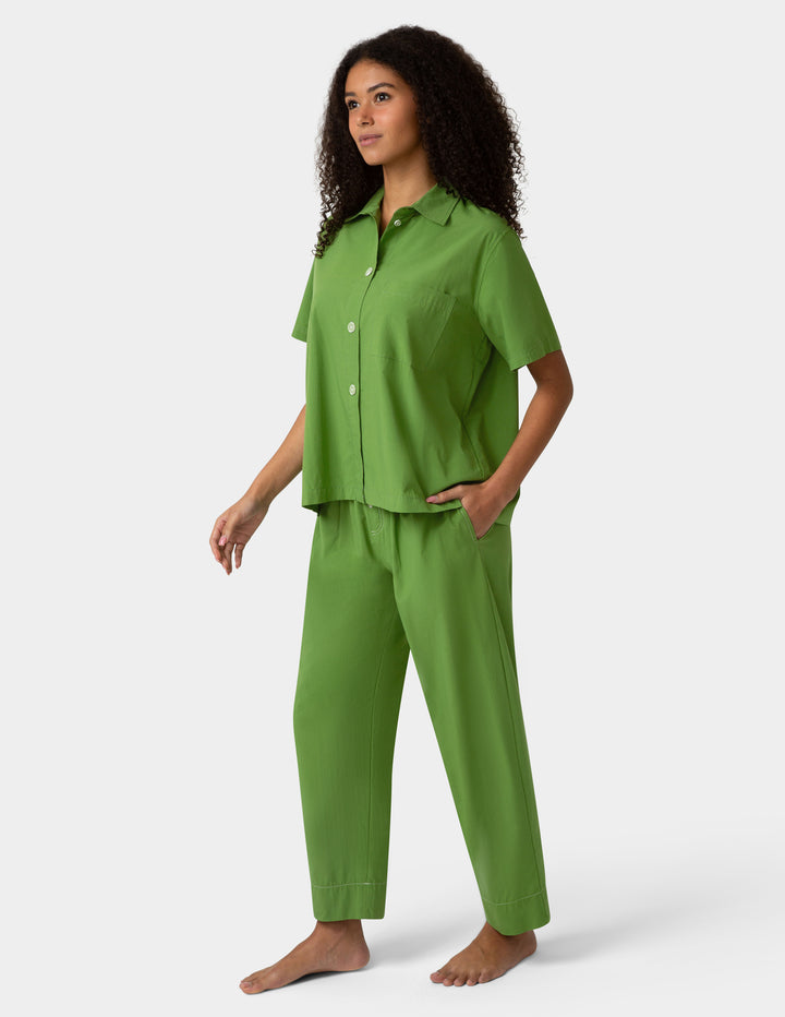 Woman wearing a green pajama set on a white background